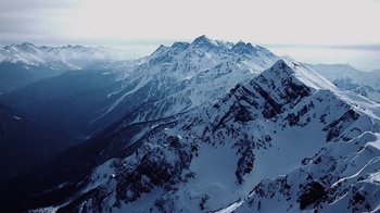 Movie still from “Icarus” (2017), directed by Bryan Fogel – A view of a mountain range from a helicopter; Extreme Wide shot, High angle