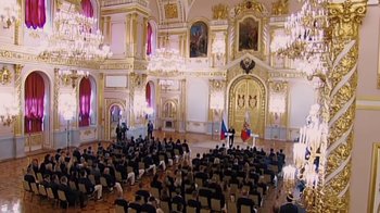 Movie still from “Icarus” (2017), directed by Bryan Fogel – A group of people sitting in a large room with chairs; Extreme Wide shot, High angle