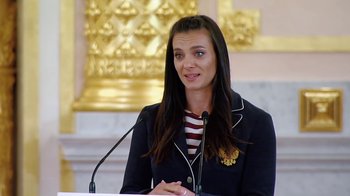 Movie still from “Icarus” (2017), directed by Bryan Fogel – A woman is speaking in front of a microphone; Medium shot, Low angle