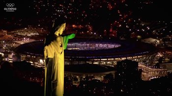 Movie still from “Icarus” (2017), directed by Bryan Fogel – A statue of jesus points to a stadium at night; Extreme Wide shot, Low angle