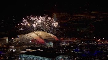 Movie still from “Icarus” (2017), directed by Bryan Fogel – Fireworks explode over a stadium at night in a city; Extreme Wide shot, Overhead angle