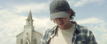 Movie still from “In the Tall Grass” (2019), directed by Vincenzo Natali – A man wearing a hat and a plaid shirt; Close Up shot, Low angle