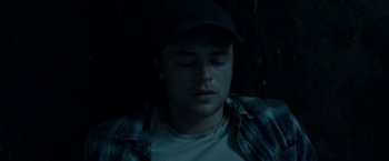 Movie still from “In the Tall Grass” (2019), directed by Vincenzo Natali – A man with his eyes closed in the dark; Close Up shot, Overhead angle