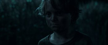 Movie still from “In the Tall Grass” (2019), directed by Vincenzo Natali – A young man is looking into the camera; Close Up shot, Low angle