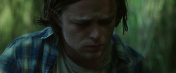 Movie still from “In the Tall Grass” (2019), directed by Vincenzo Natali – A person wearing headphones and looking down; Close Up shot, Low angle