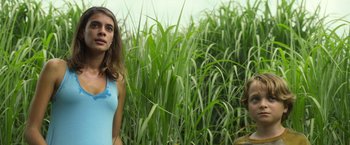 Movie still from “In the Tall Grass” (2019), directed by Vincenzo Natali – A woman standing next to another woman in a grassy field; Medium shot, Low angle