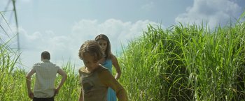 Movie still from “In the Tall Grass” (2019), directed by Vincenzo Natali – A young boy and a young girl walking through tall grass; Medium shot, Low angle
