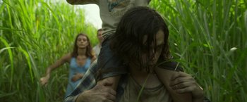 Movie still from “In the Tall Grass” (2019), directed by Vincenzo Natali – A group of people in a field with trees in the background; Medium shot, Low angle