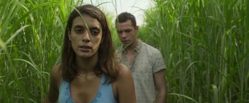 Movie still from “In the Tall Grass” (2019), directed by Vincenzo Natali – A man and a woman standing next to each other in tall grass; Close Up shot, Over the shoulder angle