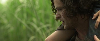Movie still from “In the Tall Grass” (2019), directed by Vincenzo Natali – A person with long brown hair; Close Up shot, Low angle