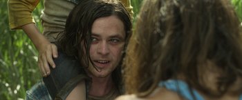 Movie still from “In the Tall Grass” (2019), directed by Vincenzo Natali – A man with long brown hair looking into a mirror; Close Up shot, Over the shoulder angle