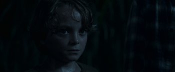 Movie still from “In the Tall Grass” (2019), directed by Vincenzo Natali – A young boy is looking into the camera; Close Up shot, Low angle