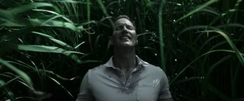 Movie still from “In the Tall Grass” (2019), directed by Vincenzo Natali – A man in a white shirt is in the grass; Close Up shot, Low angle