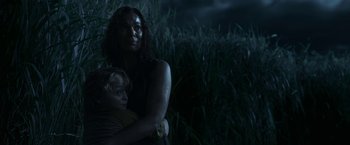 Movie still from “In the Tall Grass” (2019), directed by Vincenzo Natali – A woman and a child in a field at night; Medium shot, Low angle