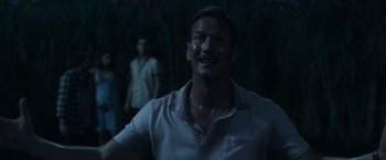 Movie still from “In the Tall Grass” (2019), directed by Vincenzo Natali – A man in a white shirt is looking at the camera; Close Up shot, Over the shoulder angle