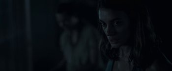 Movie still from “In the Tall Grass” (2019), directed by Vincenzo Natali – A woman is looking at the camera in the dark; Close Up shot, Over the shoulder angle