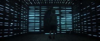 Movie still from “In the Tall Grass” (2019), directed by Vincenzo Natali – A man standing in front of a wall of lights; Wide shot, Low angle