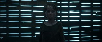 Movie still from “In the Tall Grass” (2019), directed by Vincenzo Natali – A young girl standing in front of a wall of lights; Close Up shot, Low angle