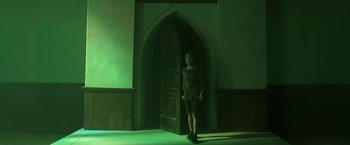 Movie still from “In the Tall Grass” (2019), directed by Vincenzo Natali – A person standing in front of a door in a room; Wide shot, Low angle