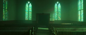 Movie still from “In the Tall Grass” (2019), directed by Vincenzo Natali – A church with two stained glass windows in the middle of the room; Extreme Wide shot, Low angle