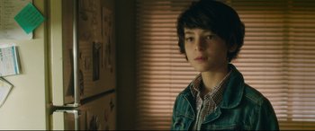 Movie still from “Incarnate” (2016), directed by Brad Peyton – A young man standing in front of a window; Close Up shot, Over the shoulder angle