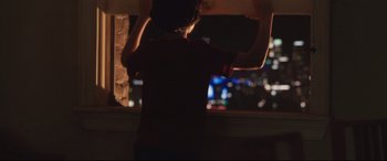 Movie still from “Incarnate” (2016), directed by Brad Peyton – A person standing in front of a window at night; Medium shot, Over the shoulder angle