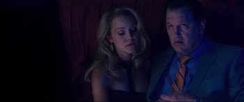 Movie still from “Incarnate” (2016), directed by Brad Peyton – A beautiful woman sitting next to a man in a dark room; Medium shot, Overhead angle