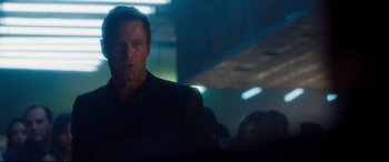 Movie still from “Incarnate” (2016), directed by Brad Peyton – A person wearing a suit in a room; Close Up shot, Over the shoulder angle