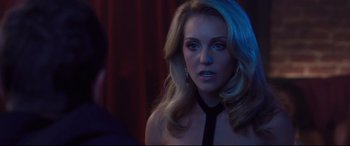 Movie still from “Incarnate” (2016), directed by Brad Peyton – A woman with blonde hair wearing a black neck tie; Close Up shot, Over the shoulder angle