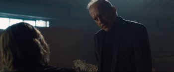 Movie still from “Incarnate” (2016), directed by Brad Peyton – An older man standing in a dark room; Medium shot, Low angle