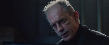 Movie still from “Incarnate” (2016), directed by Brad Peyton – An older man with grey hair looking at the camera; Close Up shot, Low angle