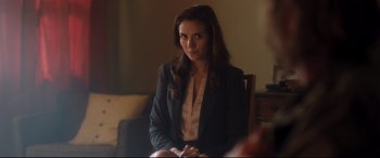 Movie still from “Incarnate” (2016), directed by Brad Peyton – A woman sitting in a chair wearing a black jacket; Medium shot, Over the shoulder angle