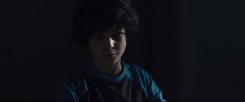 Movie still from “Incarnate” (2016), directed by Brad Peyton – A young boy is looking at the camera; Close Up shot, Low angle