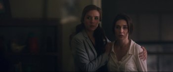 Movie still from “Incarnate” (2016), directed by Brad Peyton – Two women standing next to each other in front of a mirror; Medium shot, Over the shoulder angle