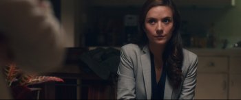 Movie still from “Incarnate” (2016), directed by Brad Peyton – A woman sitting in a chair in front of a bookshelf; Close Up shot, Over the shoulder angle