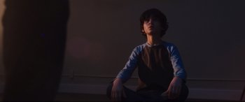 Movie still from “Incarnate” (2016), directed by Brad Peyton – A young boy sitting on the ground in a room; Medium shot, Low angle