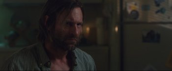 Movie still from “Incarnate” (2016), directed by Brad Peyton – A person with long hair and a beard; Close Up shot, Over the shoulder angle