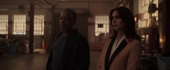 Movie still from “Kaleidoscope” (2023), directed by Mairzee Almas – A man and a woman standing next to each other in a room; Medium shot, Over the shoulder angle