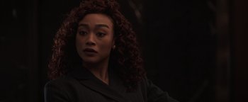 Movie still from “Kaleidoscope” (2023), directed by Mairzee Almas – A person with curly hair; Close Up shot, Over the shoulder angle