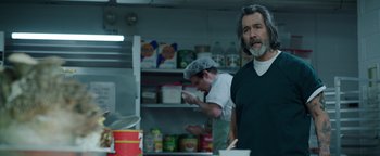 Movie still from “Kaleidoscope” (2023), directed by Mairzee Almas – A man standing in front of an open refrigerator; Medium shot, Over the shoulder angle