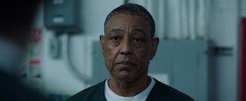 Movie still from “Kaleidoscope” (2023), directed by Mairzee Almas – An older man is looking into the camera; Close Up shot, Low angle