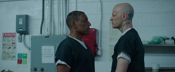 Movie still from “Kaleidoscope” (2023), directed by Mairzee Almas – Two men are facing each other in a room; Medium shot, Over the shoulder angle