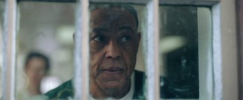 Movie still from “Kaleidoscope” (2023), directed by Mairzee Almas – An older man looking through the bars of a jail cell; Close Up shot, Low angle
