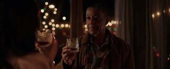 Movie still from “Kaleidoscope” (2023), directed by Mairzee Almas – An older man holding a glass of whiskey; Close Up shot, Over the shoulder angle