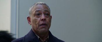 Movie still from “Kaleidoscope” (2023), directed by Mairzee Almas – An older man is looking at the camera; Close Up shot, Low angle