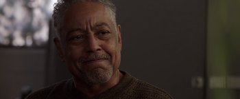 Movie still from “Kaleidoscope” (2023), directed by Mairzee Almas – An older man wearing a brown sweater looking at the camera; Close Up shot, Low angle