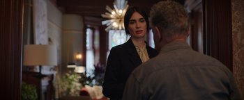 Movie still from “Kaleidoscope” (2023), directed by Mairzee Almas – A woman in a suit talking to an older man; Medium shot, Over the shoulder angle