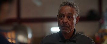 Movie still from “Kaleidoscope” (2023), directed by Mairzee Almas – An older man with gray hair is looking at the camera; Close Up shot, Low angle