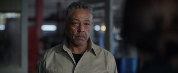 Movie still from “Kaleidoscope” (2023), directed by Mairzee Almas – An older man in a tan shirt is looking at the camera; Close Up shot, Over the shoulder angle