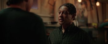 Movie still from “Kaleidoscope” (2023), directed by Mairzee Almas – A man in a green shirt is looking at the camera; Close Up shot, Over the shoulder angle